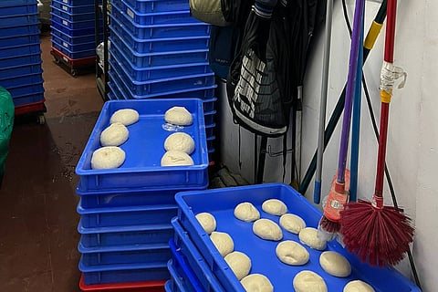 Image of mops and toilet brushes in close proximity to Domino’s pizza doughs