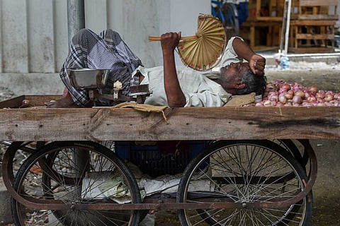 A vegetable seller takes rest on cart as Chennai city reels under a heat wave in 2019
