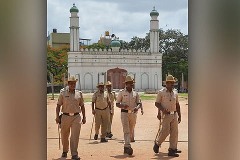 Policemen walking near the Idgah maidan in Chamarajpet in Bengaluru