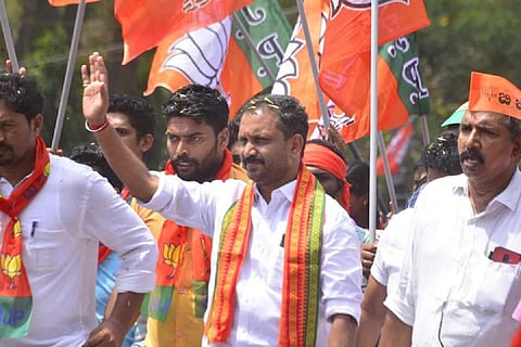 Kerala state BJP President K Surendran waving to supporters during campaigning