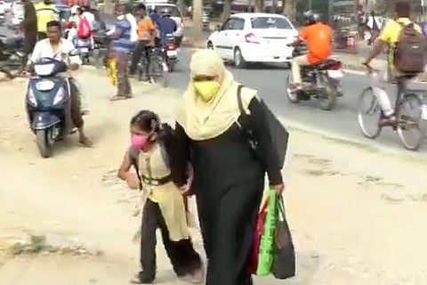 A teacher wearing burqa entering the school on Monday