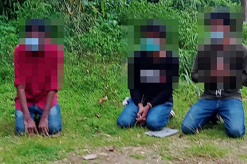 3 men kneeling on ground