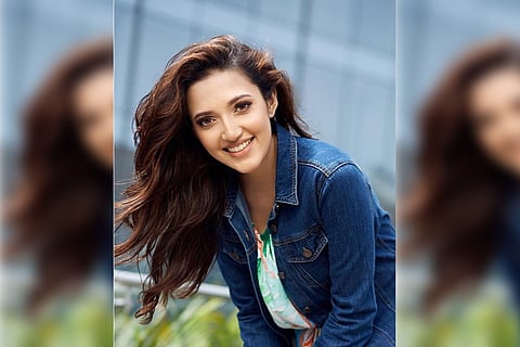 Actor Neha Shetty posing in a denim jacket