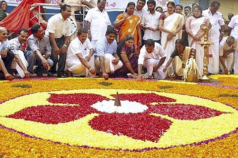 People posing with pookalam during Onam