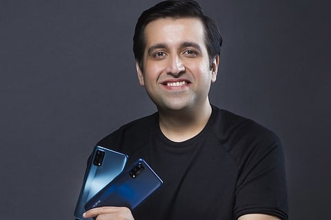 Realme CEO dressed in black and smiling