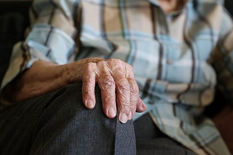 Hands of an elderly man placed on his knees