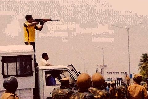 A police personnel firing from the top of a vehicle