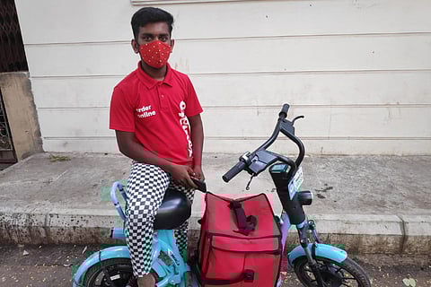 A delivery person using an electric vehicle