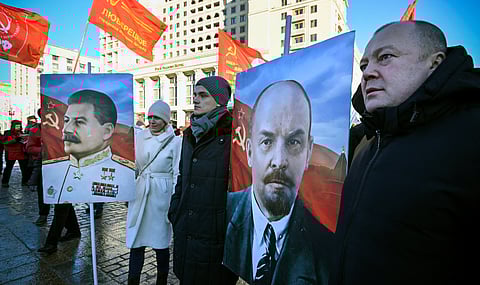 Russian communist supporters hold portraits of Soviet leaders Vladimir Lenin (R) and Joseph Stalin, before a flower-laying ceremony at the mausoleum of the founder of the Soviet state, Vladimir Lenin, to mark the 100th anniversary of his death, in Moscow on January 21, 2024.