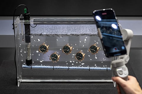 FILE: Watches are seen in water at the booth of Swiss watch manufacturer IWC on the opening day of during the luxury watch fair 'Watches and Wonders Geneva', on 27 March 2023 in Geneva.