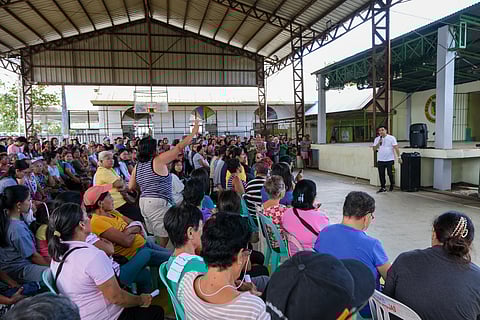 BARANGAY Aga chairperson Jeoprey Sumague (standing, holding a microphone) addresses a question by a constituent during a town hall meeting over the weekend on their looming eviction from the lands they are tilling in Nasugbu, Batangas. About 50,000 agrarian reform beneficiaries are fighting to keep their Certificates of Land Ownership Award from being rescinded by the Department of Agrarian Reform.