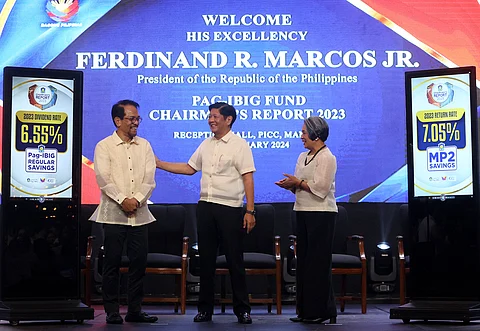 Record-breaking President Ferdinand R. Marcos Jr. (left) shares a light conversation with Department of Human Settlements and Urban Development Secretary Jose Rizalino L. Acuzar during the Pag-IBIG Fund Chairman’s Report at the Philippine International Convention Center on Tuesday. Marcos said the national government’s task is clear: to build the most number of housing units by any administration. He praised Pag-IBIG Fund, headed by CEO Marilene Acosta (right), for attaining its highest-ever net income of P49.79 billion in 2023, 97.86 percent of which will go to members' dividends.