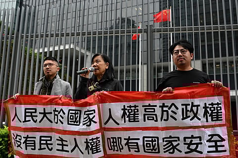 Members of the League of Social Democrats hold up a banner which reads "Without democracy, there can be no livelihood, "Put the people above the country, human rights above the regime, There can be no national security without democracy and human rights." outside the Central Government offices in Hong Kong on February 27, 2024.