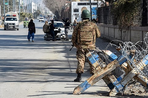A Pakistani army personnel stands guard along a road in Quetta on February 7, 2024, a day prior Pakistan's national elections. At least 24 people were killed on February 7 by two separate bomb blasts outside the offices of election candidates in southwestern Pakistan, on the eve of a national vote marred by violence and allegations of poll rigging.