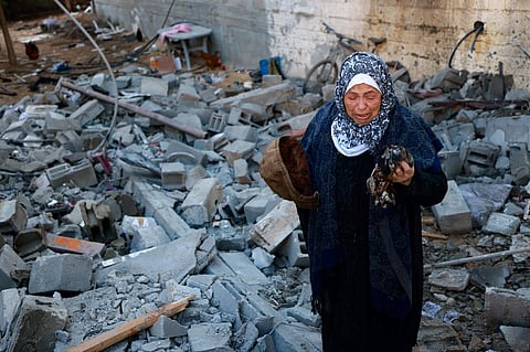 A woman reacts upon finding clothing items of a killed relative among rubble of a destroyed house, following Israeli bombardment in Rafah in the southern Gaza Strip on February 3, 2024, as fighting continues between Israel and the Palestinian Hamas group.