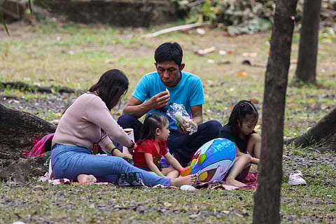 FILES: Families often have a picnic beneath the shade of trees at Luneta Park.