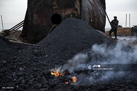 (FILES) A picture taken on 11 January 2024 shows a worker posing for a picture at a primitive oil facility in the Abu Ghadir area, of Syria's northeastern Kurdish-controlled Qamishli district.