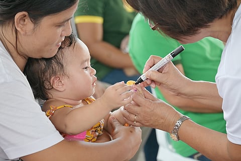 A CHILD gets her pinky finger marked after receiving the polio vaccine in a health center in Tacloban City.