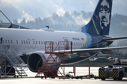 (FILES) Alaska Airlines N704AL, a 737 Max 9, which made an emergency landing at Portland International Airport on January 5 is parked at a maintenance hanger in Portland, Oregon on 23 January 2024. The missing emergency door is covered and taped. Aviation giant Boeing has been unable to produce key information about work performed on an Alaska Airlines plane before a January mid-air scare, said the National Transportation Safety Board chair in a letter on 13 March 2024.