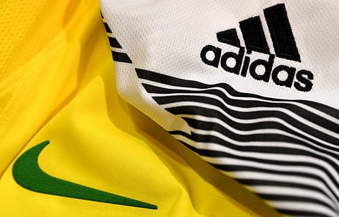 (FILES) A picture taken on 25 April 2018 in Paris, shows the logo of sports wear manufacturers Nike and Adidas for the FIFA 2018 World Cup football tournament.