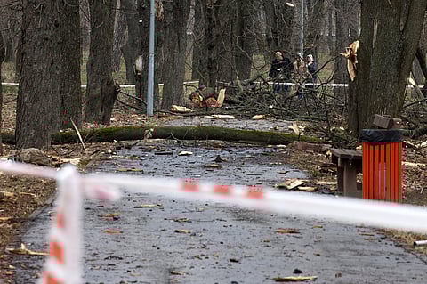 Local residents walk near the site of a rocket strike in one of the parks after a Russian missile attack in Kyiv, on 24 March 2024, amid the Russian invasion in Ukraine.