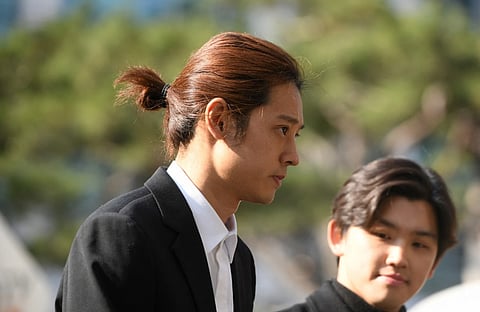K-pop star Jung Joon-young (C) arrives for questioning at the Seoul Metropolitan Police Agency in Seoul on 14 March 2019.