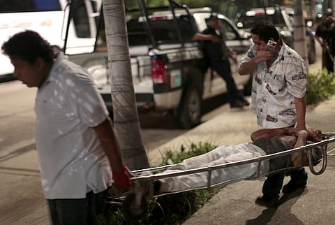 (FILES) Forensic officers carry body of one of two bodies executed at Papagayo beach in the tourist city of Acapulco, Guerrero state on 21 June 2015. Guerrero is one of Mexico's poorest and most violent states, where a lucrative drug trade has flourished.