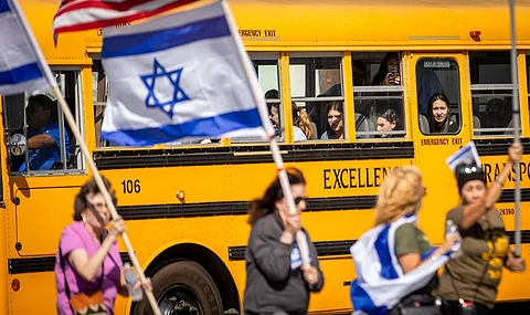 (FILES) Children watch through the window of a school bus as demonstrators attend a rally in solidarity with Israel on 10 October 2023 in Los Angeles, California. The show of support comes amid the weekend attacks on Israel by the Palestinian militant group Hamas which has claimed hundreds of lives and wounded thousands more.