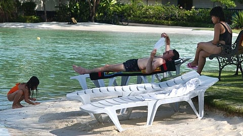 (FILES) A western tourist and family rest at a resort in Mactan island, Cebu.