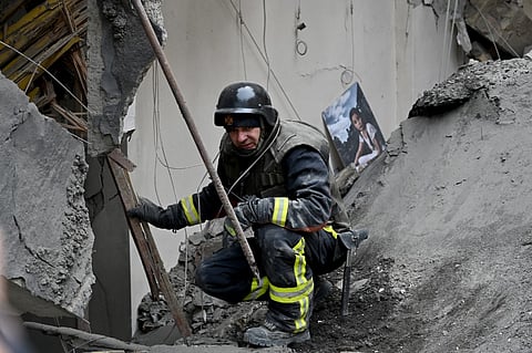 A Ukrainian rescuer works at the site of a missile attack in Kyiv on 25 March 2024, amid the Russian invasion of Ukraine. Five people including a teenage girl were injured on 25 March 2024 during a Russian missile attack on Kyiv, where falling debris also damaged at least two buildings in central districts. Russia has escalated aerial attacks on Kyiv in recent days, targeting key infrastructure in the wake of fatal Ukrainian bombardments on Russian border regions.