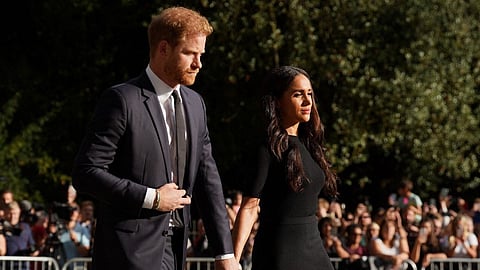 (FILES) Britain's Prince Harry, Duke of Sussex (L) and Meghan, Duchess of Sussex (R) arrive to look at floral tributes on the Long walk at Windsor Castle on 10 September 2022.