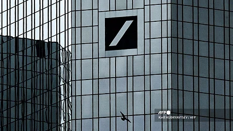 A bird flies close to the Deutsche Bank building with the bank's logo in the banking district in Frankfurt am Main, western Germany, on 16 April 2024. 
