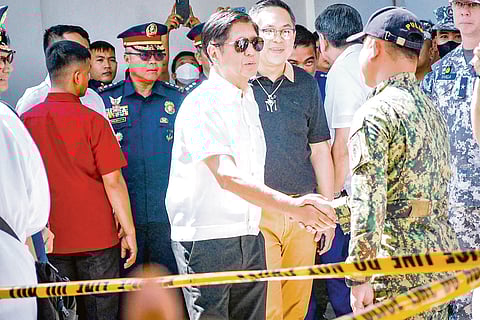 Police hero President Ferdinand R. Marcos Jr. shakes hands with P/Capt. Luis De Luna in Alitagtag, Batangas on Tuesday. De Luna led the confiscation of two tons of shabu worth P13.3 billion at a checkpoint in Barangay Pinagkurusan, Alitagtag on Monday, earning him a well-deserved promotion to police major.