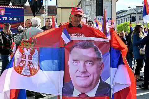 A supporter holds the Serbian flags and a poster of Bosnian Serb secessionist leader Milorad Dodik during the "Srpska Is Calling You" rally, in Banja Luka on 18 April 2024. Bosnian Serbs protested on 18 April 2024, in Banja Luka against a potential UN resolution declaring 11 July an international day to remember the Srebrenica genocide. Bosnian Serb forces captured Srebrenica — a UN-protected enclave at the time — on 11 July 1995, a few months before Bosnia's inter-ethnic war ended. In the following days they summarily killed some 8,000 Bosnian Muslim men and boys from the eastern town. Under a settlement to end the war, Bosnia was divided into two semi-autonomous zones, one run by Bosnians and Croats, and another by Serbs, with Banja Luka as its capital. Dodik, president of the Serbian entity, has been demanding even greater autonomy.