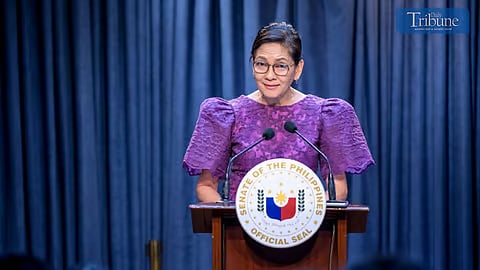 Senator Risa Hontiveros wearing a purple dress during press conference.