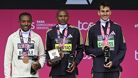 (L-R) Second place Ethiopia's Kenenisa Bekele, winner Kenya's Alexander Mutiso Munyao and third place Britain's Emile Cairess pose with their medals at the trophy presentation for the men's race at the 2024 London Marathon in Central London on 21 April 2024.