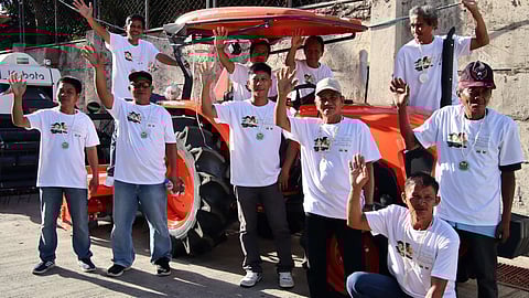 Members of the Bono-Bono Gintong Butil Multi-Purpose Cooperative happily wave after the DAR turned over to them a farm tractor worth P1.4 million.