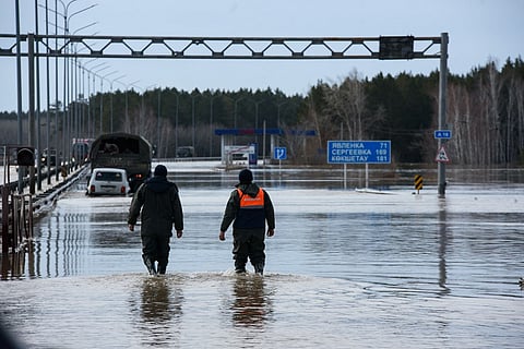 Trucks move through a flooded part of a road in the city of Petropavl in northern Kazakhstan close to the border with Russia on 14 April 2024.