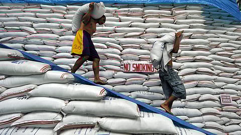 (FILE PHOTO) Grainy at the moment. While the National Food Authority officials work on sacking the rice sale scam, probe details of which remain undisclosed, workers keep the flow going, carrying sacks of rice for stacking at an NFA warehouse in Manila.