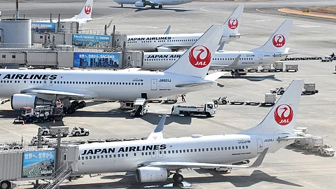 (FILES) Japan Airlines passenger planes sit on the tarmac at Tokyo's Haneda Airport on 16 February 2022, after a reported computer glitch caused delays in check-ins and flights around the country.