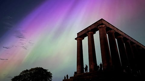 This handout photo taken and released by Jacob Anderson shows the northern lights or aurora borealis during a solar storm over the National Monument of Scotland in Edinburgh on 10 May 2024.