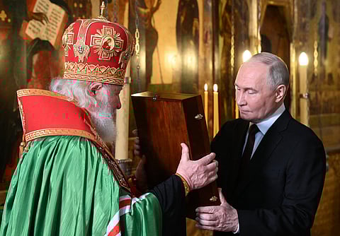 In this pool photograph distributed by Russian state agency Sputnik, Russian President Vladimir Putin (R) and Russia's Orthodox Patriarch Kirill attend a service in the Annunciation Cathedral following Putin's inauguration ceremony at the Kremlin in Moscow on 7 May 2024.