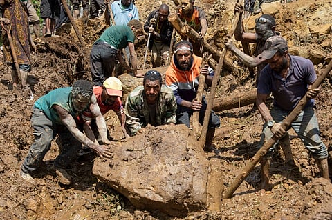 Locals dig at the site of a landslide at Mulitaka village in the region of Maip Mulitaka, in Papua New Guinea’s Enga Province. Papua New Guinea moved to evacuate an estimated 7,900 people from remote villages near the site of a deadly landslide on 28 May.