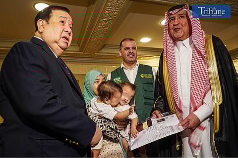 Saudi Ambassador Hisham Al-Qahtani poses with Hashima Yusoph and her conjoined twins, Philippine Red Cross CEO Richard Gordon, left, and a KSrelief representative, second from right, during a reception in Manila Friday 3 May 2024.