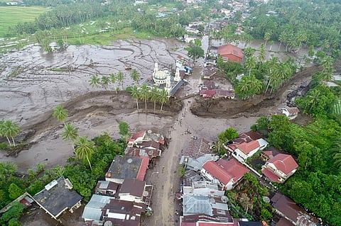 This handout aerial image taken and released by Indonesia's Disaster Mitigation Agency (BNPB) on 12 May 2024, shows the damaged area after flash floods and cold lava flow from a volcano in Tanah Datar, West Sumatra. At least 34 people have died and 16 more were missing after flash floods and cold lava flow from a volcano hit western Indonesia, a local disaster official said on 12 May.