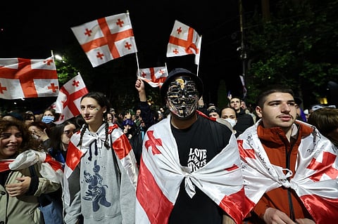 Protesters shout slogans and wave Georgian national flags during a march against the controversial "foreign influence" bill in Tbilisi, on 12 May 2024. Several thousand Georgians gathered outside parliament in Tbilisi in a fresh protest against a Russian-styled "foreign agent" bill, despite government officials warning of arrests, in Tbilisi, on 12 May 2024.