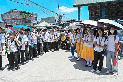 STUDENTS use umbrellas to shield themselves from the sun, but the rising heat index has prompted school and local government authorities to cancel face-to-face classes.