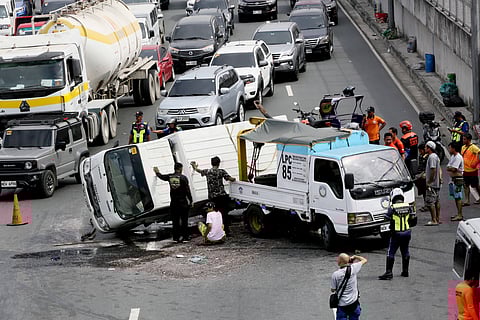VARIOUS government agencies deploy their personnel to remove a van that flipped into its side along Commonwealth Avenue in Quezon City.