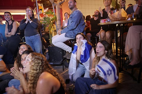 People watch the final of the 68th Eurovision Song Contest (ESC) 2024 at a bar in Tel Aviv on 11 May 2024. The Eurovision Song Contest final gets underway in Sweden's Malmo on Saturday, as tensions mount around Israel's participation during the Gaza war. Israel is one of 25 nations competing in a contest watched around the world by millions of lovers of the pop sounds — and kitschy shows.