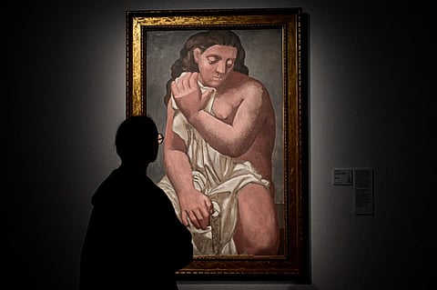 A visitor looks at a painting by Pablo Picasso entitled "Grand nu a la draperie" (Large nude in the drapery) during a press preview of the Cezanne / Renoir exhibition, at Palazzo Reale in Milan.